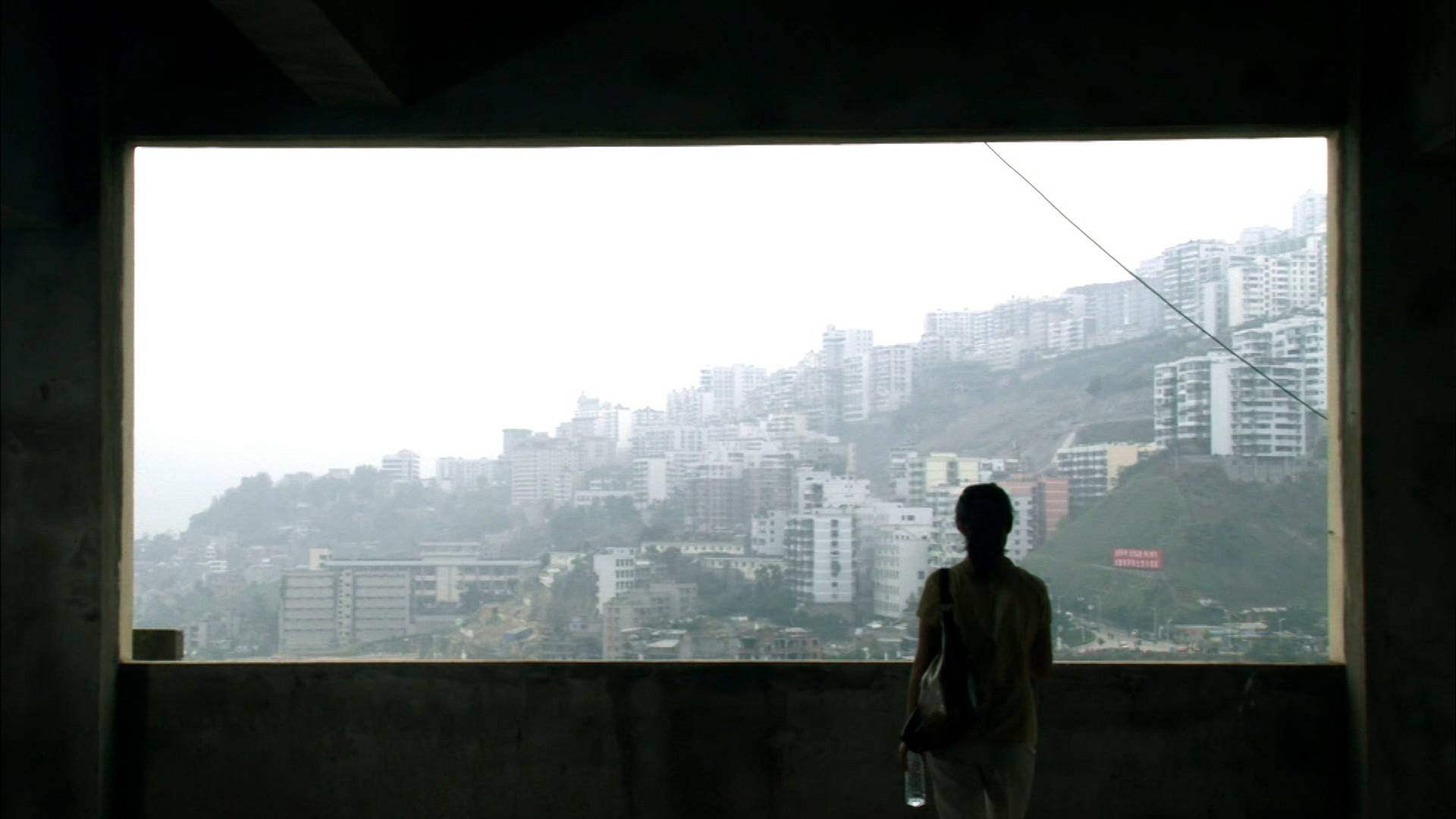 Woman looking out at mountain-side village